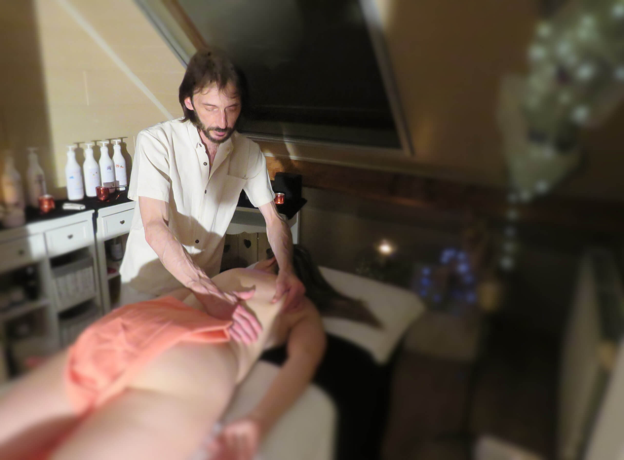 De eigenaar van Caress Bourdin Massage masseert een vrouw die op haar buik op een massagetafel ligt.